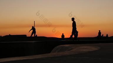 轮廓年轻的跳滑板者骑冲浪老手夏天日落背景威尼斯海洋海滩滑板运动场地这些洛杉矶加州青少年滑板斜坡极端的公园集团青少年